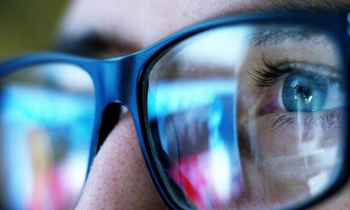 worker with reflection of the future in glasses