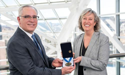 Elevations Credit Union CEO Gerry Agnes and Board Chair Kate Brown holding Malcolm Baldrige award medal