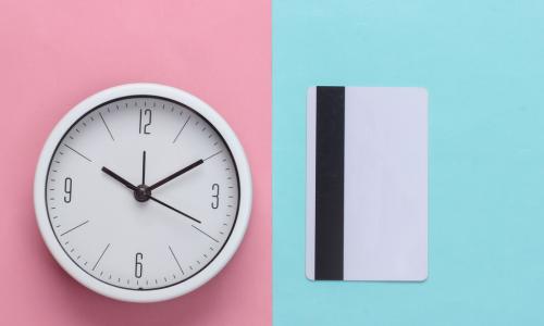white clock and credit card on blue and pink