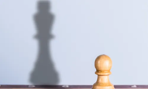 pawn with king shadow on chessboard