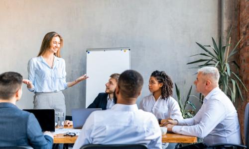 confident young businesswoman presenting to a diverse team at the office