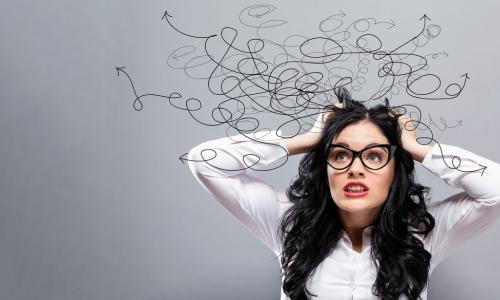 stressed young businesswoman wearing glasses pulls her hair while thinking about tangled mess of options