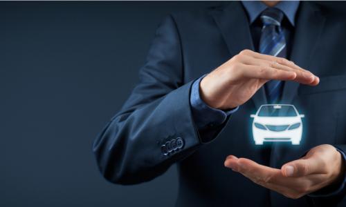 businessman holds and protects small car in his hands