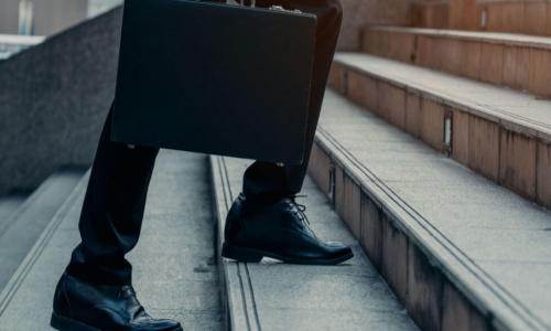 a businessman with a briefcase walks up stairs