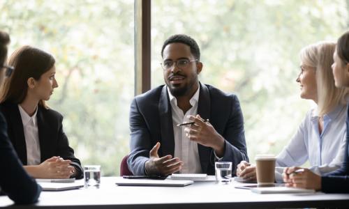 engaged Black business leader holding discussion with employee team