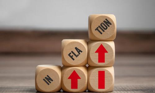 wooden blocks with up arrows and word inflation stacked into a staircase