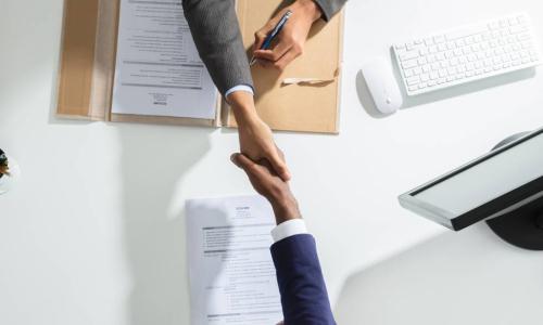 businessperson shaking hands over a table