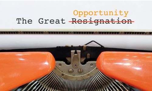 The Great Resignation typed text above orange typewriter with word Resignation crossed out and Opportunity typed above it