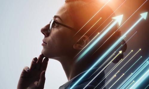 businesswoman in glasses holding chin while staring thoughtfully into space