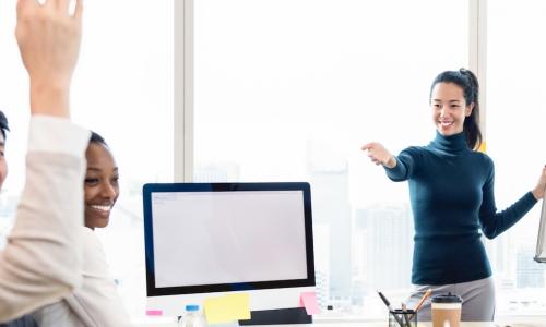 confident young businesswoman asks question to team during presentation