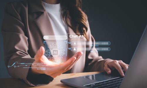 businesswoman using laptop holds digital artificial intelligence AI interface in hand