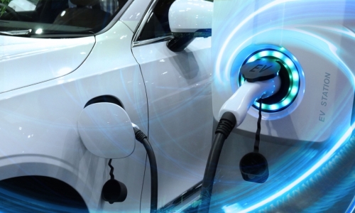 a white electric vehicle is plugged in and charging
