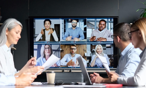Board members sitting around a large screen showing the board portal for a meeting