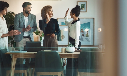 two women hands up for a high-five behind a table