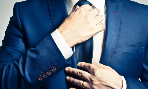 torso of male straightening his tie