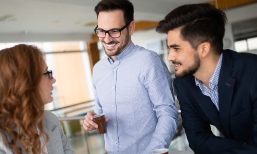 2 males speaking to a female