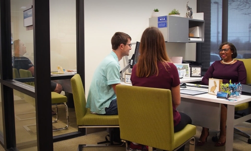 young couple sitting at loan officers desk