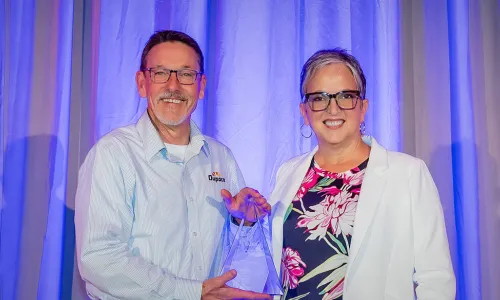 Joe Hearn accepting award from CUES CEO Heather McKissick