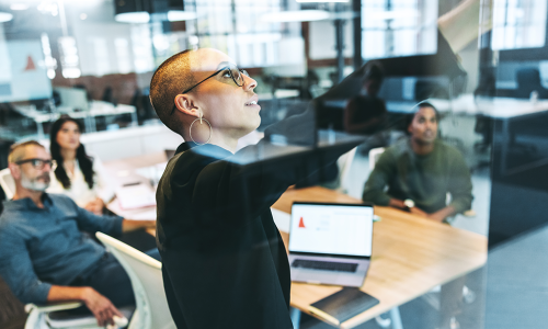 woman pointing at board in meeting