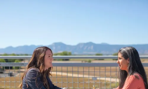 2 women talking at outdoor table