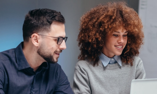 man and woman looking at laptop